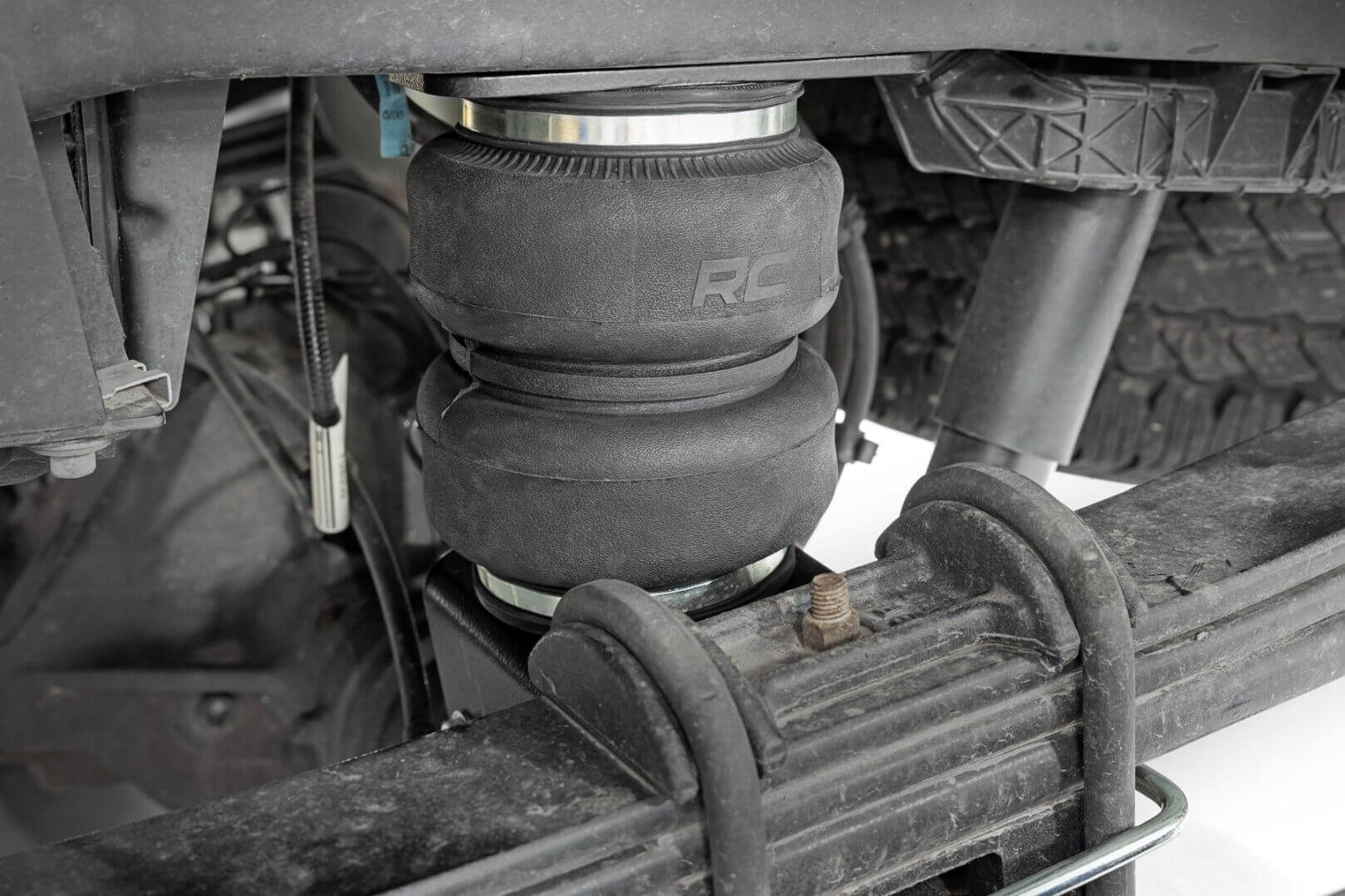 Truck suspension with airbag and leaf spring.