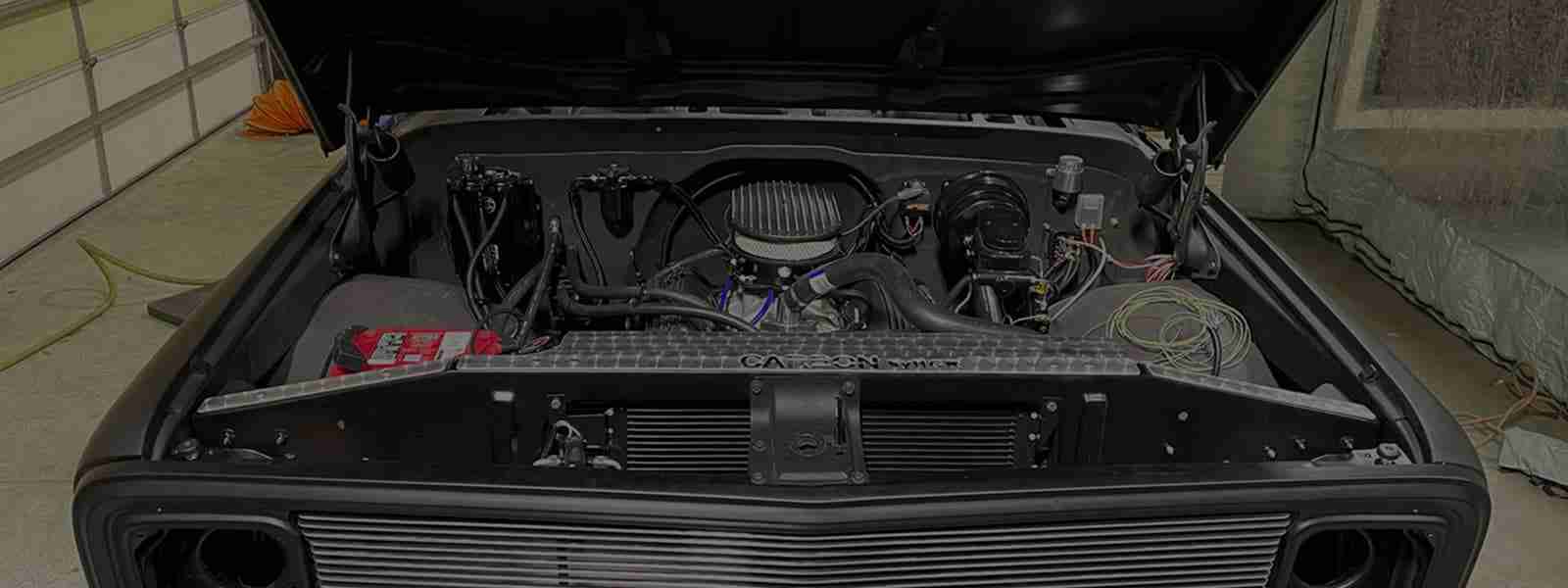 A truck engine compartment with the hood open.